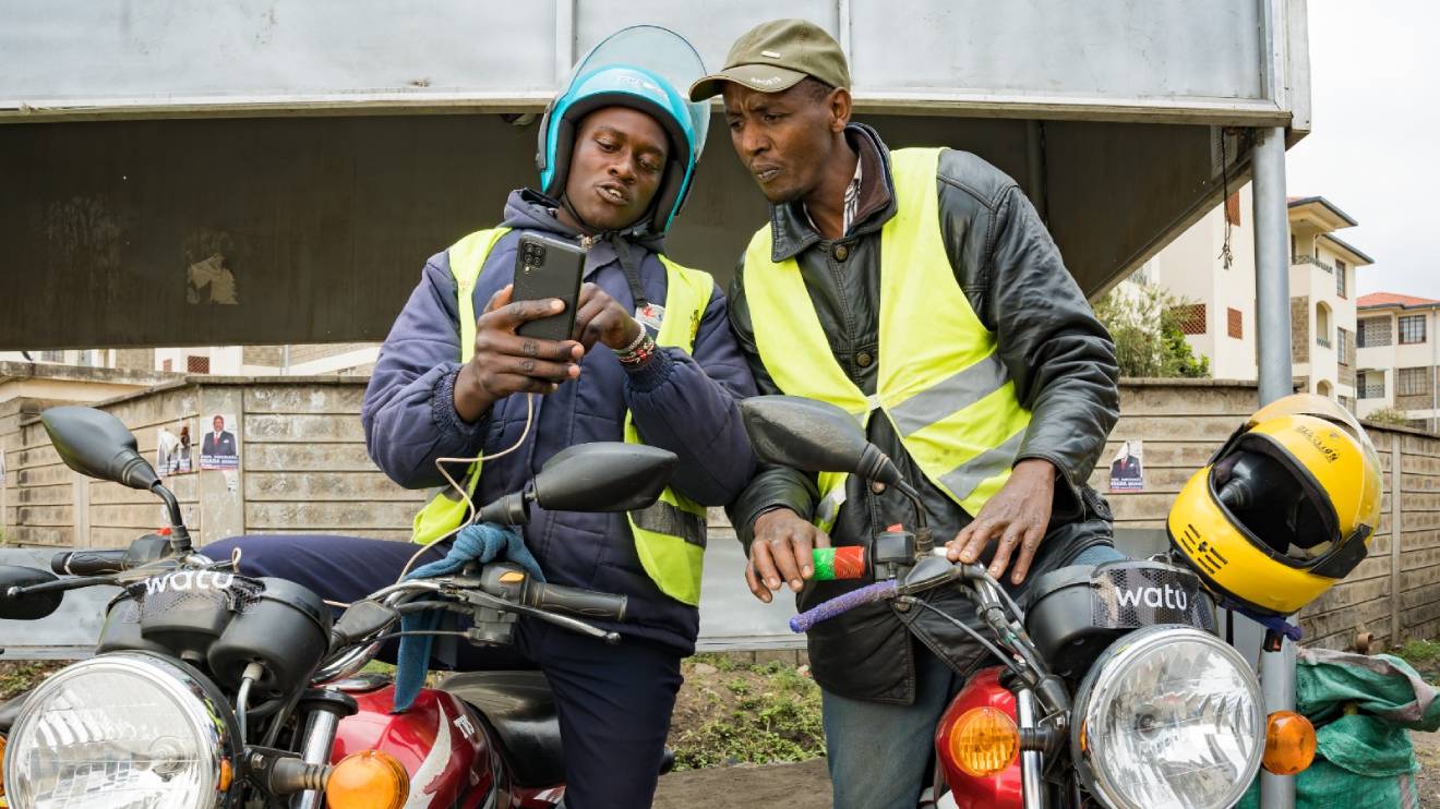 Boda Boda riders reviewing some operating features on a smartphone. PHOTO/COURTESY